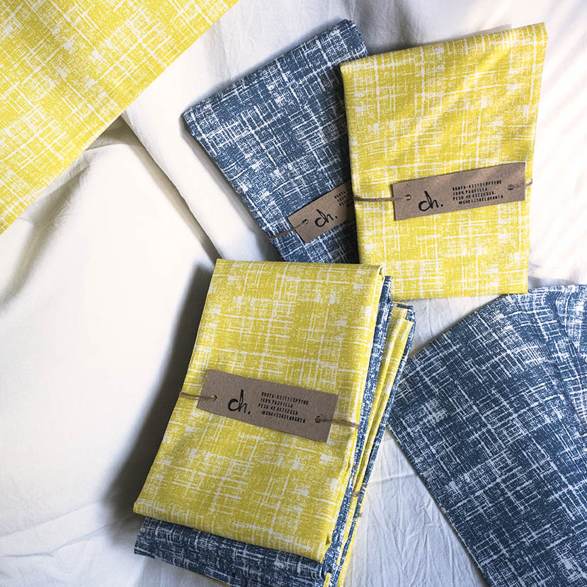 Routa-keittiöpyyhkeet valkoista taustaa vasten. Viikattuina ja vyötteellisinä, värivaihtoehdot sininen ja keltainen